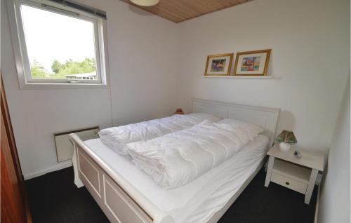 Bett mit weißer Bettwäsche in einem Zimmer mit Fenster in der Unterkunft Cozy Home In Hjslev With House Sea View in Lund