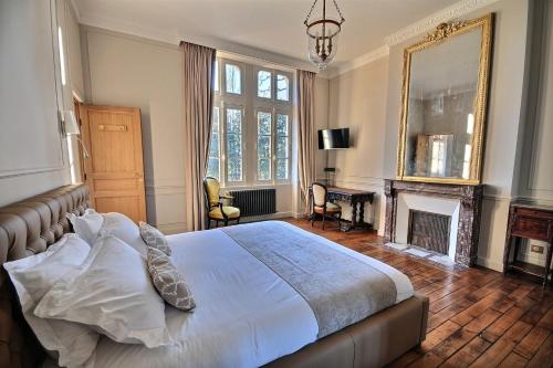 a bedroom with a large bed and a fireplace at Château de la Bribourdière in Putot-en-Auge
