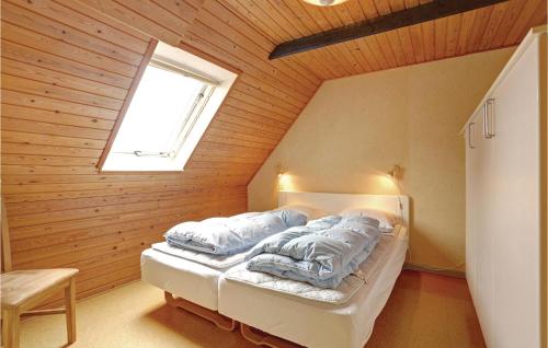 ÅkirkebyにあるStangegaardのベッドルーム1室(窓のある屋根裏部屋のベッド1台付)