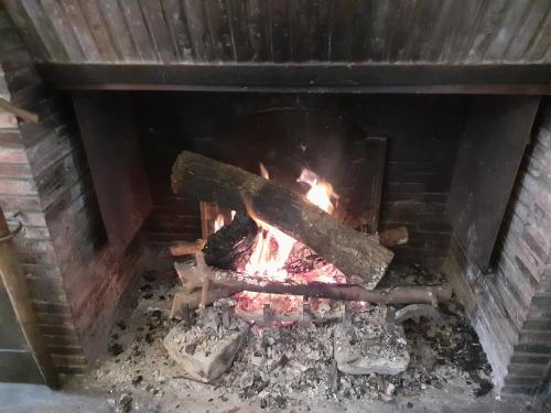 a fire in a brick fireplace at Manoir de l'As de Trèfle in Isneauville
