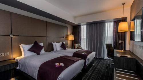 a hotel room with two beds and a desk at Crowne Plaza Aberdeen Airport by IHG in Dyce