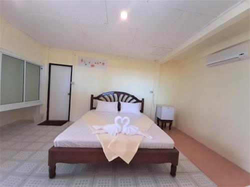 a bedroom with a bed with a ribbon on it at Cameron Island Resort in Ko Sukon