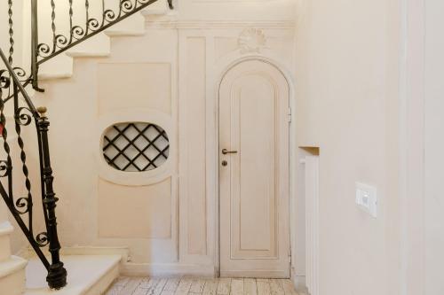 Un pasillo blanco con una puerta blanca y escaleras en Residenza del Cedro en Roma