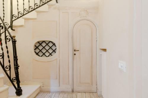 een witte hal met een witte deur en een trap bij Residenza del Cedro in Rome