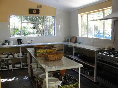 a kitchen with a counter with a table in it at Angela's Guest House in Marico-Wes