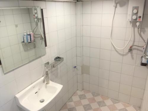 uma casa de banho com um lavatório e um chuveiro com um espelho. em Cameron Island Resort em Ko Sukon