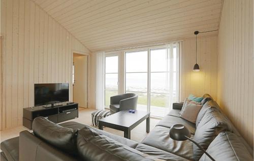 a living room with a couch and a television at Hvilen in Snogebæk