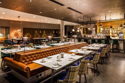a restaurant with tables and chairs and a bar at Crowne Plaza Aberdeen Airport by IHG in Dyce