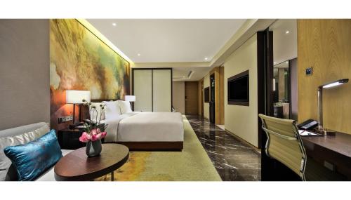 a hotel room with a bed and a living room at Crowne Plaza Chengdu Wenjiang by IHG in Chengdu
