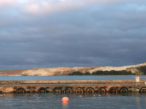 a bridge over a body of water with mountains in the background at Curonian Coast studio in Nida