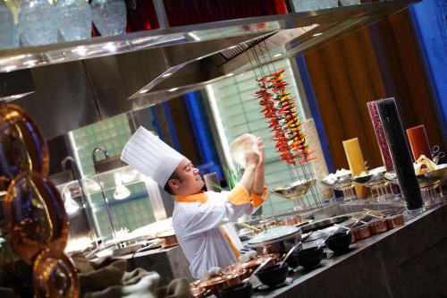 a chef is preparing food in a kitchen at Crowne Plaza Chongqing New North Zone by IHG in Chongqing