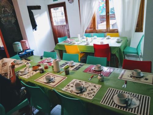 een eetkamer met 2 tafels en kleurrijke stoelen bij Hostel Punto Patagónico Neuquén in Neuquén
