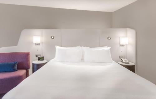 a bedroom with a large white bed and a couch at Crowne Plaza Cleveland at Playhouse Square by IHG in Cleveland