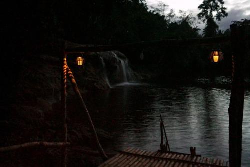 a waterfall on the side of a lake at night at Pandora Glamping in Quezon
