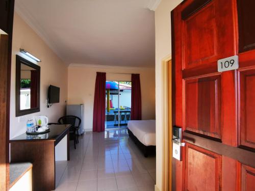 een kamer met een slaapkamer met een bed en een keuken bij Casa Idaman Motel in Pantai Cenang