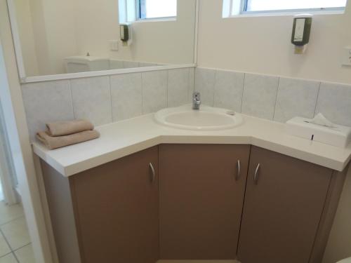 a bathroom with a sink and a mirror at Adina Place Motel Apartments in Launceston