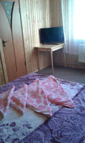 a bed with pillows on top of it with a table at Marichka in Yablunytsya
