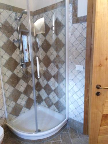 a shower with a glass door in a bathroom at Locanda Mulino del Barone by VM in Opi