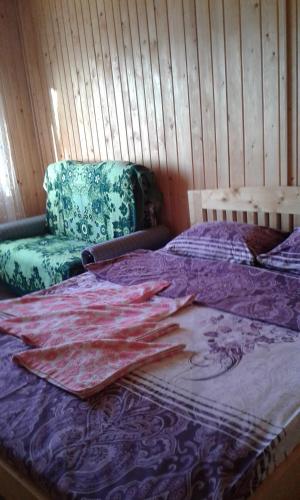 a bedroom with a bed and a couch and a bedspread at Marichka in Yablunytsya