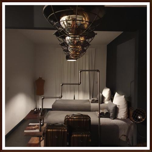 ein Schlafzimmer mit zwei Betten, einer Lampe und Gepäck in der Unterkunft Kolev Apartments in Kelsterbach