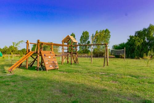 an empty playground with a swing set in a field at Cabañas Viento Andino in San Rafael