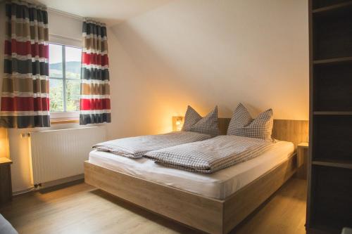 a bedroom with a bed with pillows and a window at Landurlaub in Schmallenberg Landhäuschen in Schmallenberg