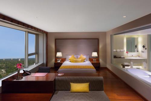 a bedroom with a large bed and a bath tub at Crowne Plaza Kochi by IHG in Cochin