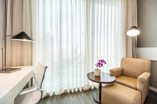 a hotel room with a desk and a chair and a table at Crowne Plaza Barranquilla by IHG in Barranquilla