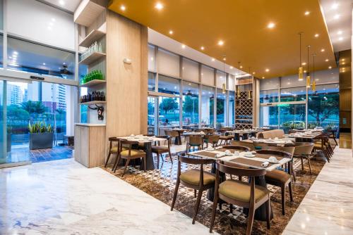 a restaurant with tables and chairs and windows at Crowne Plaza Barranquilla by IHG in Barranquilla