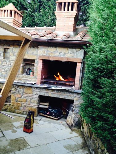 a brick fireplace with a fire in it at Appartamento in Villa con Piscina - Mhateria Relais in Rignano sullʼArno