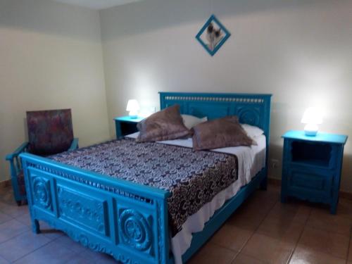 - une chambre avec un lit bleu et 2 tables de chevet dans l'établissement Gîte Etxe Xuri, à Ossès