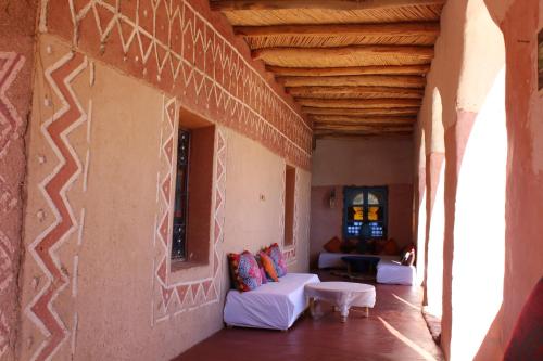um quarto com um sofá e uma mesa num edifício em Dar Timitar em El Kelaa des Mgouna