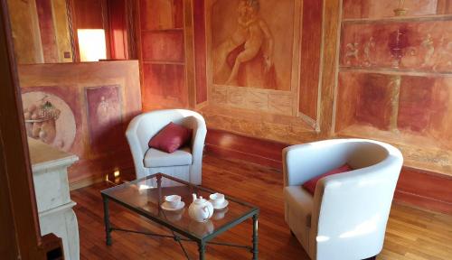 a living room with two chairs and a coffee table at La Villa des Arts in Savigné-lʼÉvêque