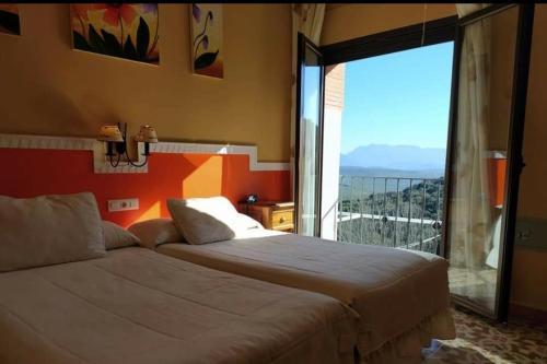 ルセナにあるHotel Sierra de Araceli Lucenaのベッドルーム1室(ベッド2台、大きな窓付)