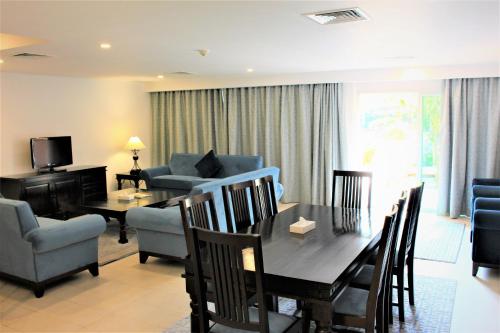 a living room with a table and a dining room at Mövenpick Hotel & Resort Al Bida'a in Kuwait