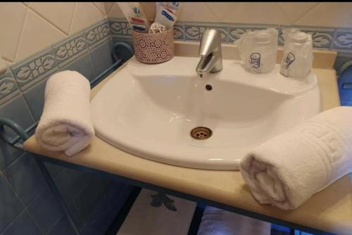 a bathroom sink with a towel on top of it at Hotel Sierra de Araceli Lucena in Lucena