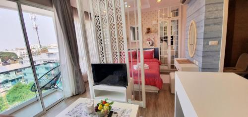 a small living room with a bed and a window at Sweet Seaview flr6 with toproop pool flr7 at The BluX Bangsaen in Bangsaen