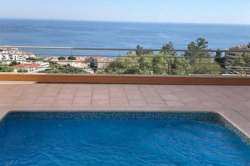 uma piscina com vista para o oceano em Luxus Ferienhaus Casa Paraiso em Sesimbra