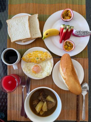 a table with plates of breakfast food on it at Hong Bin Bungalow in Phu Quoc