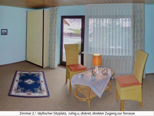 ein Wohnzimmer mit einem Tisch und Stühlen in der Unterkunft Ferienwohnung Sommerberg - Bayerische Rhön in Sondheim