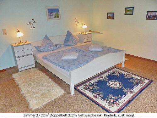 ein Schlafzimmer mit einem Bett mit zwei Nachttischen und einem Teppich in der Unterkunft Ferienwohnung Sommerberg - Bayerische Rhön in Sondheim