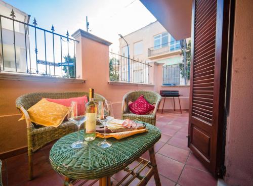 stół z kieliszkami do wina na balkonie w obiekcie Casa Goletta soggiorno per 4 a 2 minuti dalla spiaggia w mieście Cala Gonone