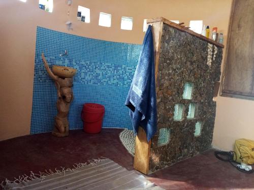 ein Bad mit einer Dusche und einer blau gefliesten Wand in der Unterkunft Saldomar B&Biosphere in Bubaque