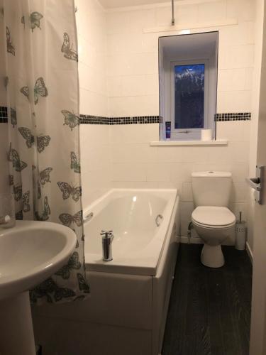 La salle de bains est pourvue d'une baignoire, de toilettes et d'un lavabo. dans l'établissement spacious 2 bedroom house, à Shotton