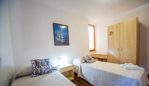 sypialnia z 2 łóżkami pojedynczymi i szafką w obiekcie Casa Goletta soggiorno per 4 a 2 minuti dalla spiaggia w mieście Cala Gonone