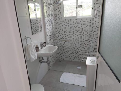 a small bathroom with a sink and a shower at Tabua Village Adventure Room #6 with Ocean View in Ribeira Brava