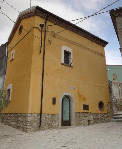 a yellow building with a window and a door at Dimora Antico Forno Soprano in Maschito
