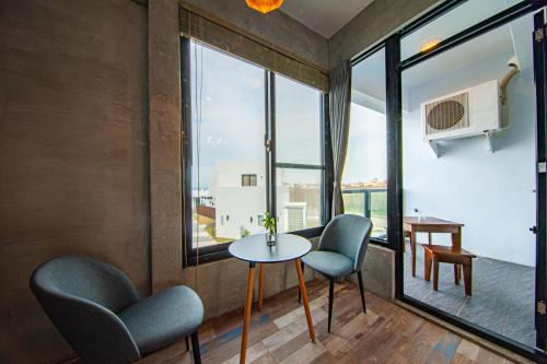 a room with a table and two chairs and a window at SH Villa in Huxi