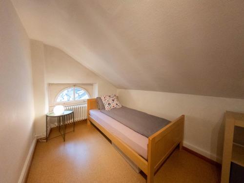 Habitación pequeña con cama y ventana en Ferienwohnung Meiringen "Engelhorn" en Meiringen