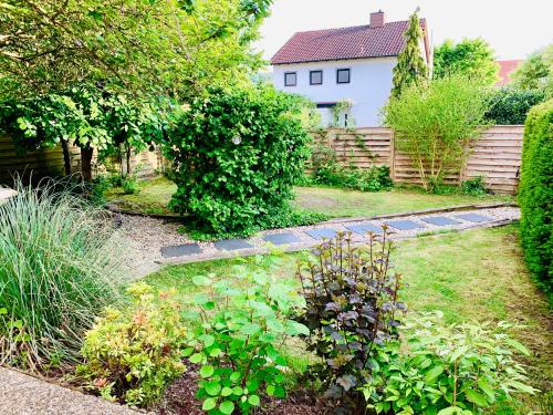 a garden with plants and a fence and a house at An der Uniklinik, Apartment mit eigener Küche und renoviertem Badezimmer, Zentrale Lage in Homburg